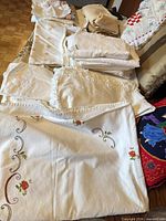 Stacked embroidered and lace tablecloths, pillowcases, cushion covers