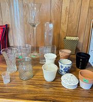 assorted vases, planters and potpourri dish grouped on wooden surface