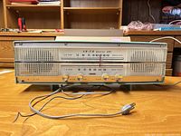 Front view of AF-610 radio showing overall design, grille, dial, knobs, and power cord