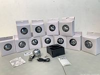 Group of 12 boxed silver apple speakers with one opened showing contents