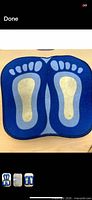 One of the blue footprint bath mats laid flat, showing full design and color