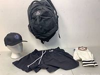 Full lot view: backpack, shorts, cap, packaged socks