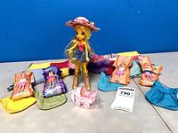 Group shot of doll, six mini dolls, purses, stroller and scarf