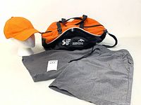 Lot overview showing duffle bag, grey shorts and orange cap