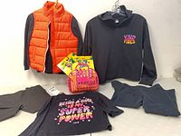 Group shot showing all clothing pieces, tote and three Crayola packs