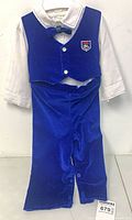 Full view of suit set hanging, showing vest, pants, shirt, bow tie