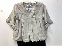 Front view of Chloe top showing label, pleats, buttons, sleeves