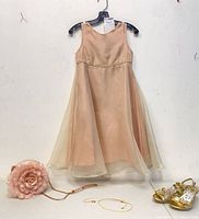 Dress on hanger with purse, shoes and necklace arranged below