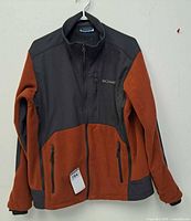 Front view of Columbia burnt orange/charcoal fleece jacket on hanger