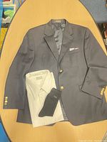 Front view of Chaps navy blazer, white shirt, black CK socks displayed on table
