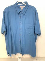 Front view of blue Quick Reflex short-sleeve shirt with chest pocket and buttons