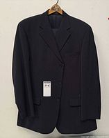 Black pinstripe men's suit jacket on hanger