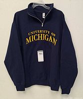 Front view shows embroidered chest logo, half-zip, overall style and navy color