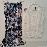 front view of patterned skirt and white top on hangers