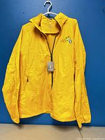 Front view of yellow Elevate windbreaker with PanAm Games logo and tag attached