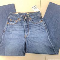 Front view of jeans laid flat showing full length and overall condition