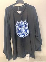 Front view of black V-neck long-sleeve hockey shirt with Wave 3E crest, size tag visible