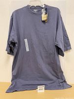 Full view of T-shirt on hanger showing colour and size tag