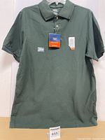 Front view of dark green Denver Hayes polo shirt with tags