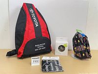 Front view of all items: Toyota backpack, boxed speaker, neck scarf, dew rag