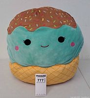 Front view of 20-inch Squishmallows ice cream cone plush with face and sprinkles