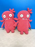 Front view of both Moxy plush toys