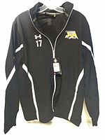 Front view of black Under Armour jacket showing white accents, number 17, embroidered logo, and hangtag