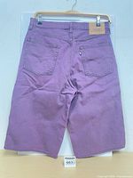 Full back view of purple denim shorts showing length, pockets, rainbow tab, leather patch
