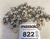 Pile of gold-tone rhinestone alphabet charms with MaxSold lot card