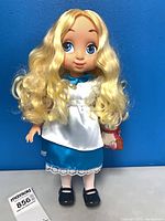 Front view of 16-inch Alice doll standing upright with tag visible