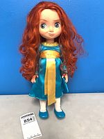 Front view of Merida doll standing, shows dress, shoes, hair