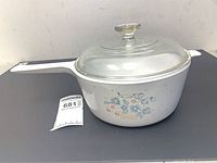 Side view of saucepan with lid showing floral basket pattern and capacity tag