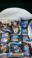 Twelve sealed Nerf Happy Meal toy packages arranged in rows