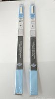 Two sealed packages of Lumi pleated paper shades side by side
