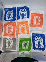Front view showing eight sealed Happy Meal toys in assorted coloured bags