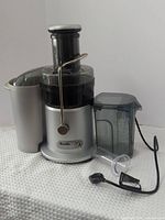 Full view of juicer assembled with pulp container, juice pitcher, food pusher and power cord