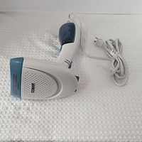 Full view of Conair handheld steamer with cord coiled