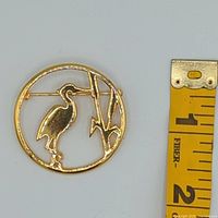 Brooch beside measuring tape for scale