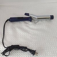 Full view of curling iron with coiled cord and plug displayed