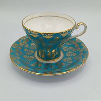 teacup resting on saucer, frontal three-quarter view showing color and pattern
