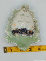 overall view of leaf-shaped souvenir dish with ruler for scale