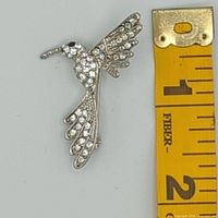 Front view next to ruler showing size under 2 inches