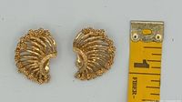 Front view of both earrings next to ruler showing size