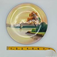 Full view of Noritake sailboat scene plate with measuring tape showing diameter