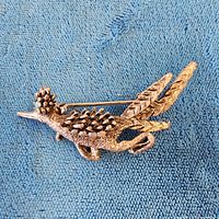 Close front view of silver-tone bird brooch showing turquoise cabochon and clasp