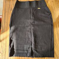 Front view of black Calvin Klein pencil skirt on wood surface