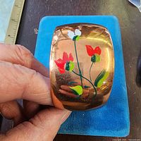 Top view of copper cuff showing floral painting and width measurement