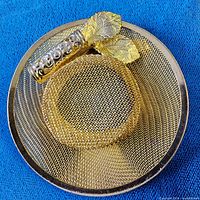front view of gold-tone hat-shaped brooch