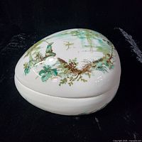 Top view of oval trinket box showing scenic design