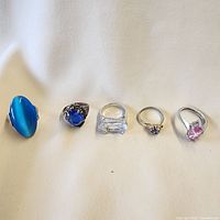 All five silver-tone rings lined up showing stone colors and designs